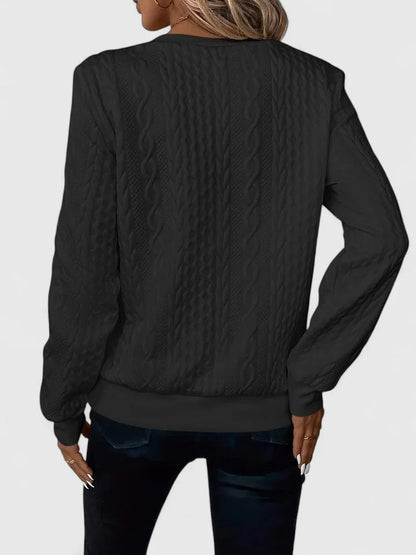 Women's cable-knit sweater with half-zip front and long sleeves